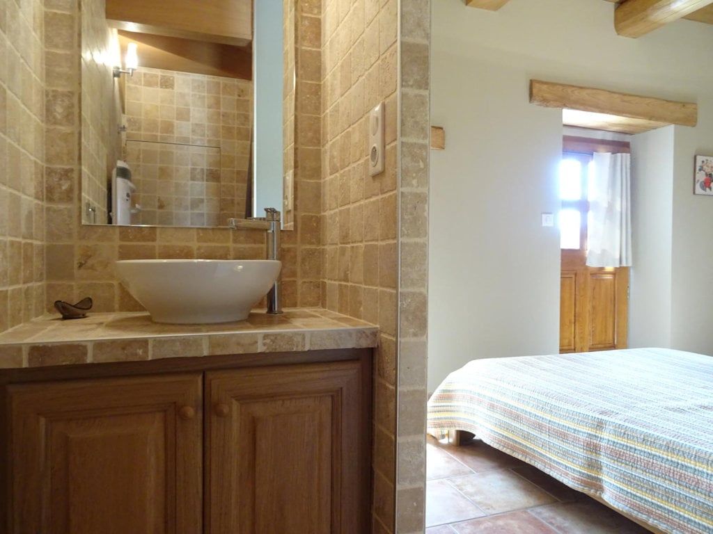 Private shower room off the ground-floor bedroom, vanity basin and stone tiling