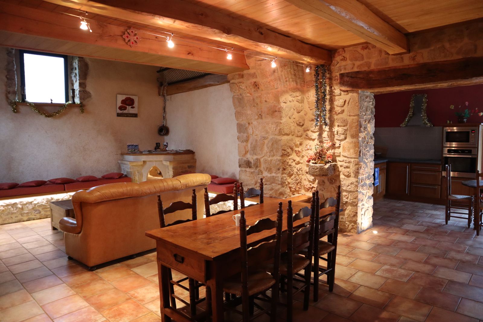 Overview of the living room, exposed stone, leather sofa and dining area
